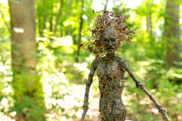 A mythical tree woman poses in three quarters view in front of a brightly lit...